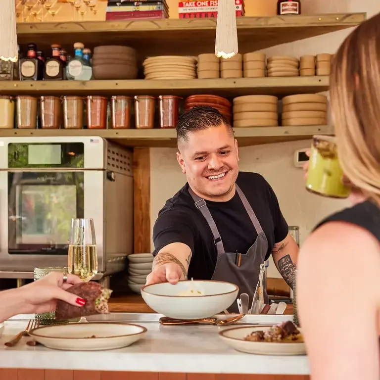 Chef servindo um prato diretamente aos clientes