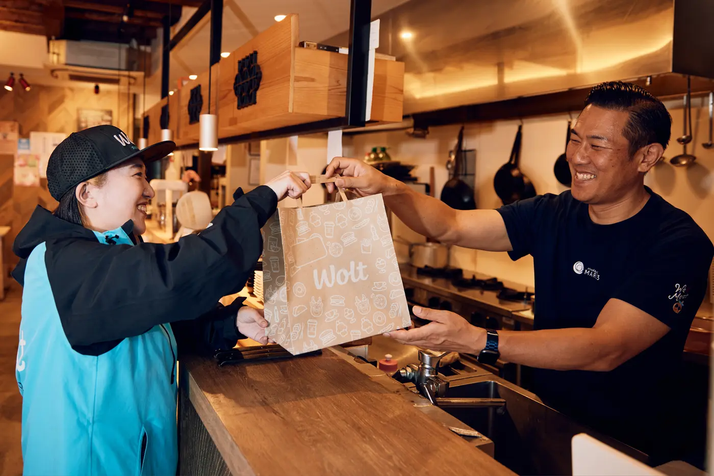 Restaurante entregando um pedido ao profissional de delivery